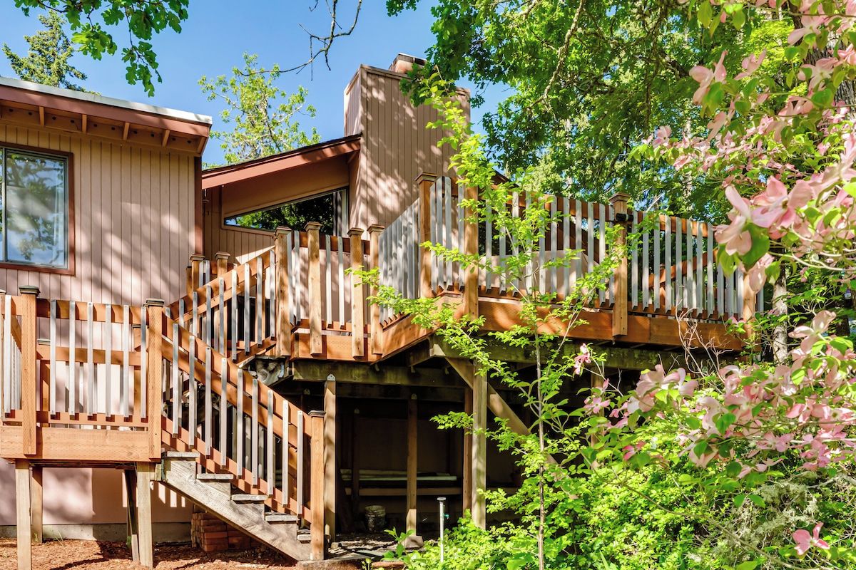 Ein Holzhaus mit Balkon und einer Treppe, die zu einer Terrasse führt.