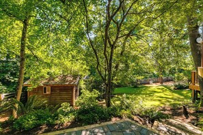 A wooden cabin surrounded by lush greenery and a well-maintained lawn. - Scenic Eugene Home w/ Deck 1mi to UofO (Eugene)