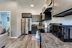 Une cuisine moderne dotée d’appareils électroménagers en acier inoxydable, de meubles en bois et d’un plan de travail en marbre.
