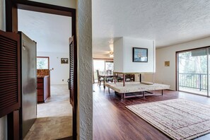 Ein geräumiges Wohnzimmer mit Essbereich, einem großen Fenster und Blick ins Freie.
