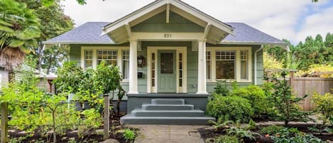 A two-story house with a green front door, a number '631' above the entrance, and a small porch with steps leading up to the door.