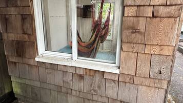 A wooden structure with a window and a hammock inside.