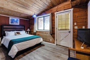 A room with a bed, a television, and a door. - Central Eugene Studio w/ Smart TV & Parking (Eugene)