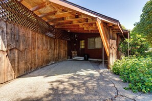 Een houten gebouw met een overdekte veranda en een oprit van beton.