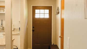 Ein Flur mit einer Holztür, einem Heizkörper und einer Bank.