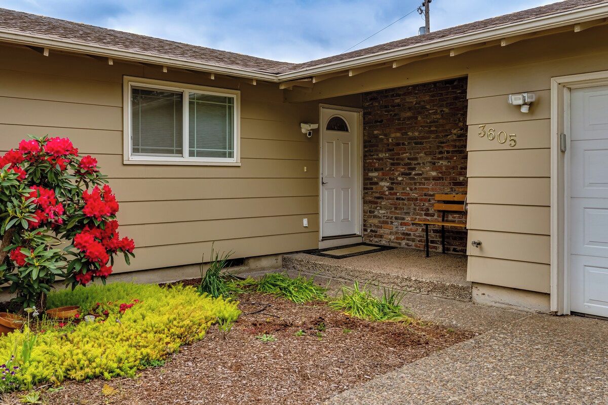 A residential house with a front door, a mailbox, and a brick wall.