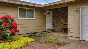 A residential house with a front door, a mailbox, and a brick wall.