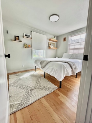 A bedroom with a bed, a window, a ceiling light, and a rug. - City-Center Home w/ Fenced Yard, Walk to Shopping (Eugene)