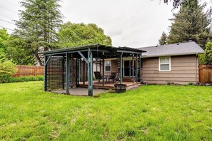 A house with a covered patio area, a fenced backyard, and a wooden fence. - Central Home, Covered Deck Near Whiteaker District (Eugene)