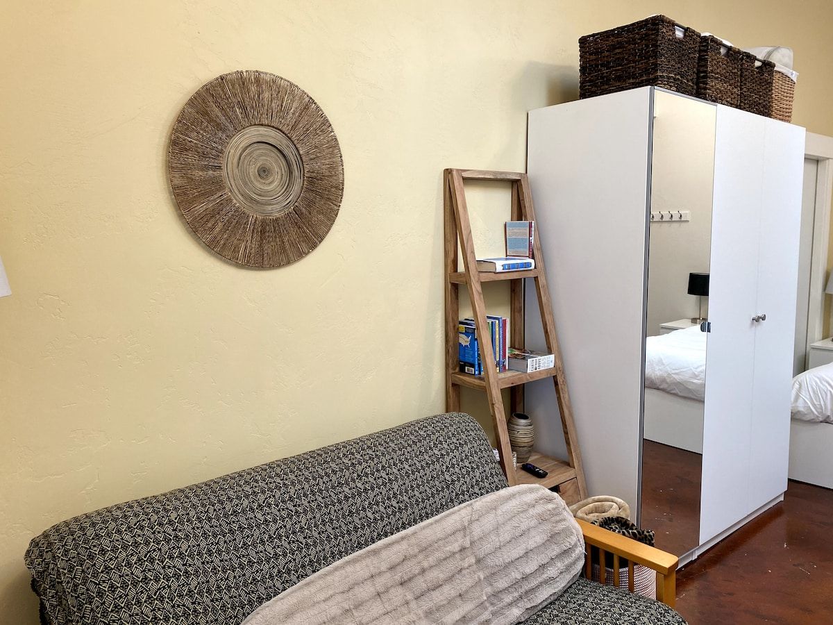 Ein Zimmer mit einer Couch, einem Schminkspiegel und einer Wanddekoration.