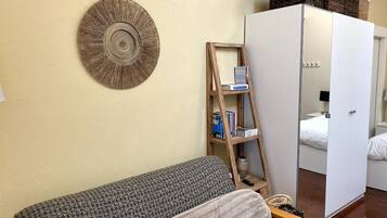 Ein Zimmer mit einer Couch, einem Schminkspiegel und einer Wanddekoration.