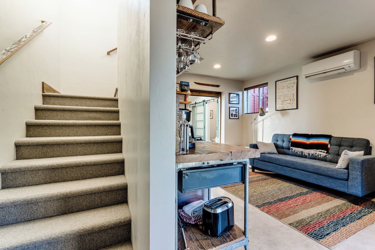 A staircase leading to a living area with a sofa and a coffee table.