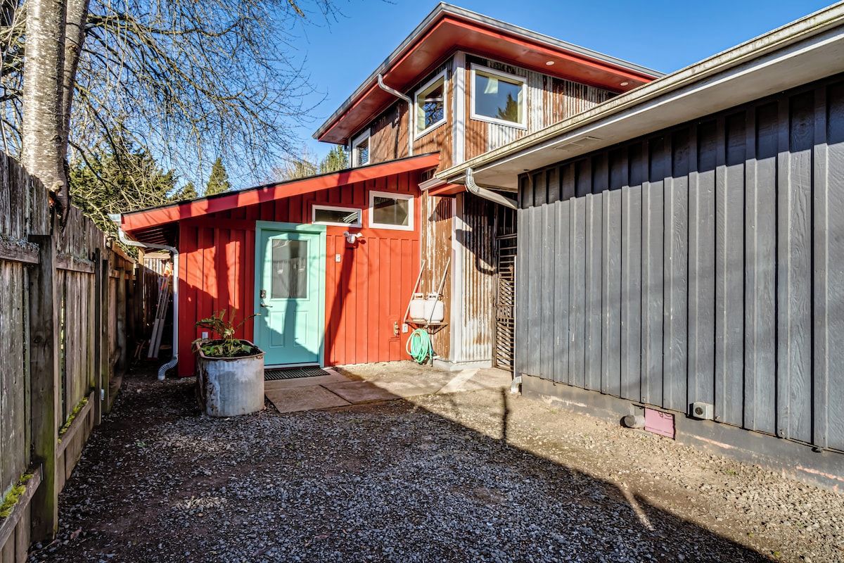 A two-story house with a red door and a garage.