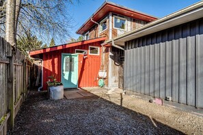 Uma casa de dois andares com porta vermelha e garagem.