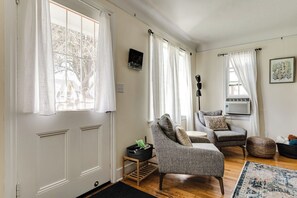 A living room with a fireplace, two armchairs, a coffee table, and a rug. - Pet-Friendly Cottage in Walkable Whiteaker w/ (Eugene)