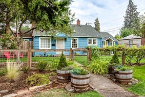 A residential property with a blue house, a fenced garden, and a wooden fence. - Dog-Friendly Studio w/ Patio & Parking, Walk to (Eugene)