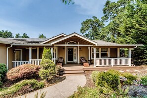 A two-story house with a front porch, a driveway, and a well-maintained garden. - Secluded Garden Retreat w/ Game Room & BBQ Patio (Eugene)