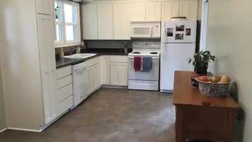 A kitchen with white cabinets, a microwave, and a refrigerator.