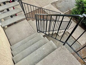 Un escalier en béton avec des rampes en métal.