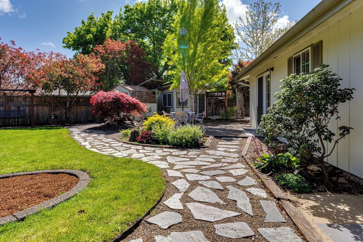 A residential property with a stone pathway leading to a covered patio area.