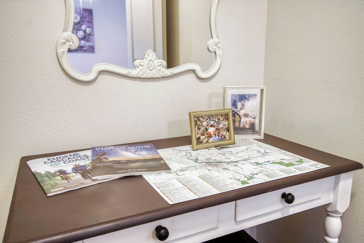 A desk with a map, a travel guide, and a framed photo.