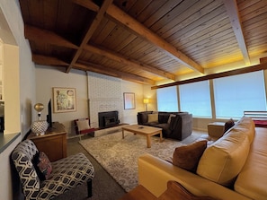 Ein Wohnzimmer mit Kamin, einer Couch, einem Couchtisch und einem gemusterten Teppich.