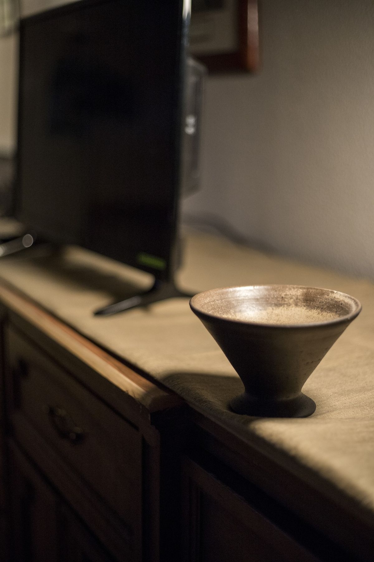 Una encimera de cocina con un tazón y un televisor.