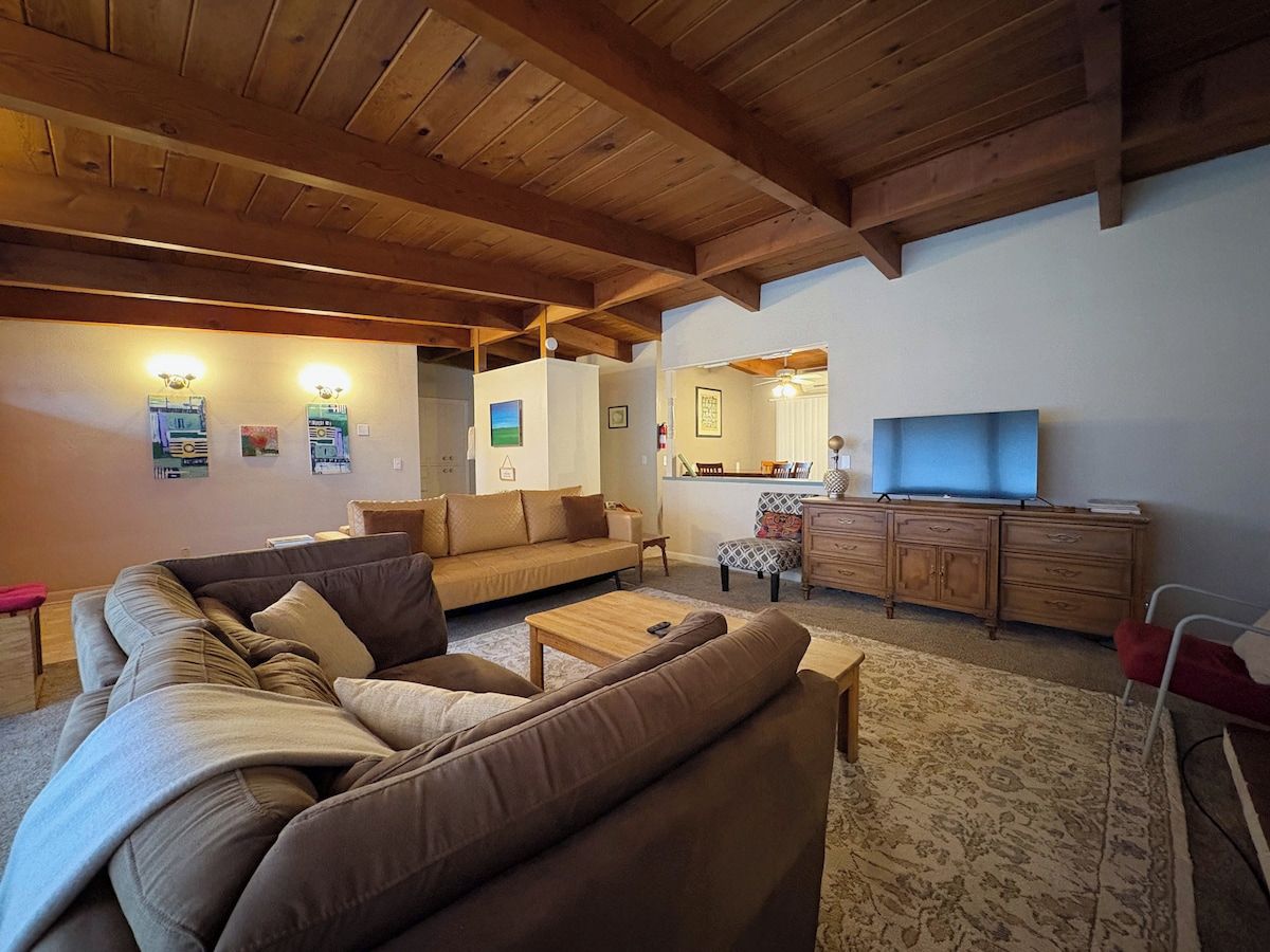 A living room with a sofa set, a coffee table, a TV, and a wooden cabinet.