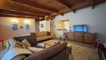 A living room with a sofa set, a coffee table, a TV, and a wooden cabinet.