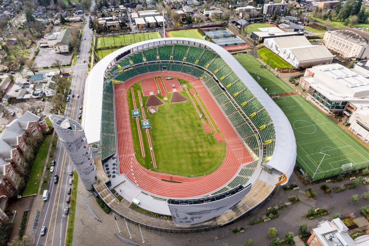 Vue aérienne d’un stade doté d’une piste d’athlétisme, de gradins et de bâtiments adjacents.