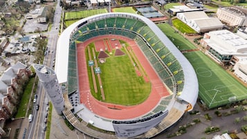 Vue aérienne d’un stade doté d’une piste d’athlétisme, de gradins et de bâtiments adjacents.