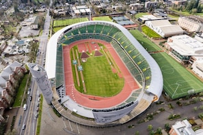 An aerial view of a stadium with a running track, seating areas, and adjacent buildings. - New Home Near Hayward Field & University, Fast (Eugene)