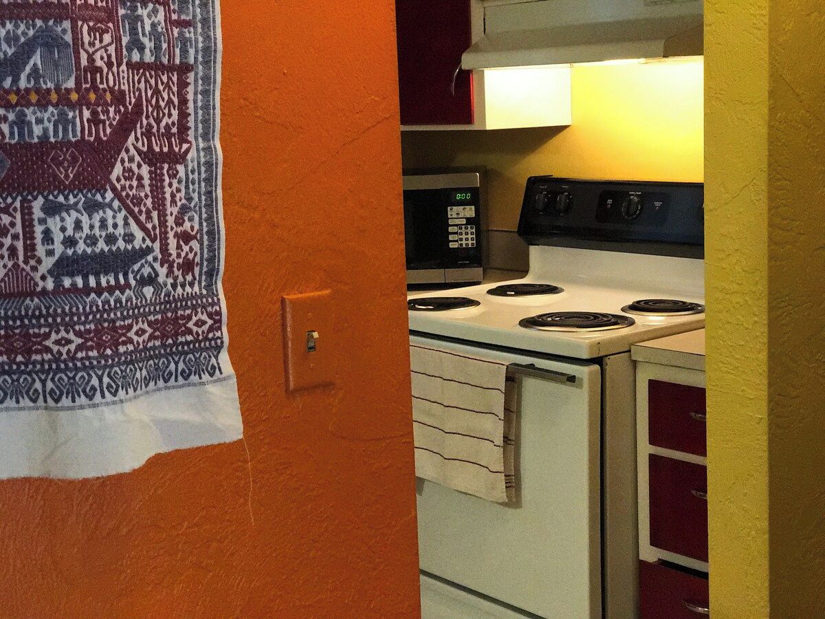 A kitchen with a microwave, stove, and cabinets.