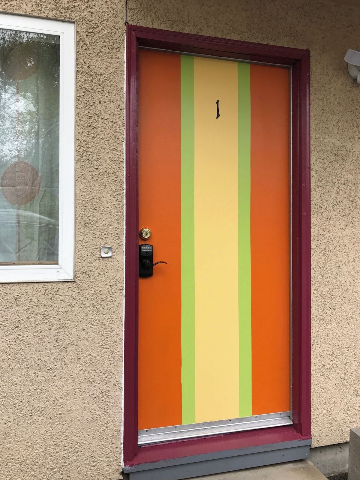 A door with a vertical stripe pattern and a numeric keypad lock.