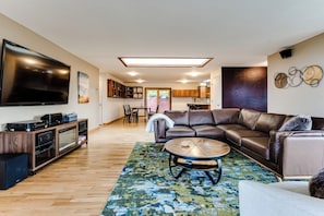 A modern living room with a leather sofa, a coffee table, a flat-screen TV, and a sound system. - Mid-Century Modern Retreat Near UO & Hayward Field (Eugene)
