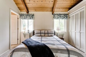 A bedroom with a bed, two bedside tables, a window with curtains, and a wardrobe with louvered doors. - Waterfront House w/ Private Dock & Game Room (Veneta)