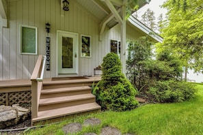 A house with a front porch, a welcome sign, and a well-maintained lawn. - Waterfront House w/ Private Dock & Game Room (Veneta)