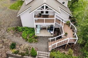 A two-story house with a balcony, a staircase, and outdoor seating area. - Waterfront House w/ Private Dock & Game Room (Veneta)