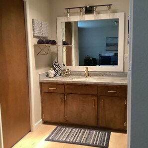 A bathroom with a large mirror, a sink, and a towel rack. - Remodeled House near Downtown Eugene w/ Free (Eugene)