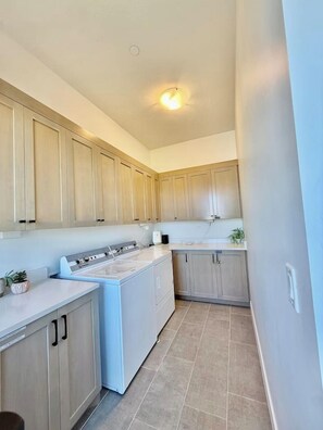 A kitchen with light wood cabinets, a white stove, and a tiled floor. - Hollow Sands Basecamp | Hot Tub | Pool | Fire Pit (Hurricane)