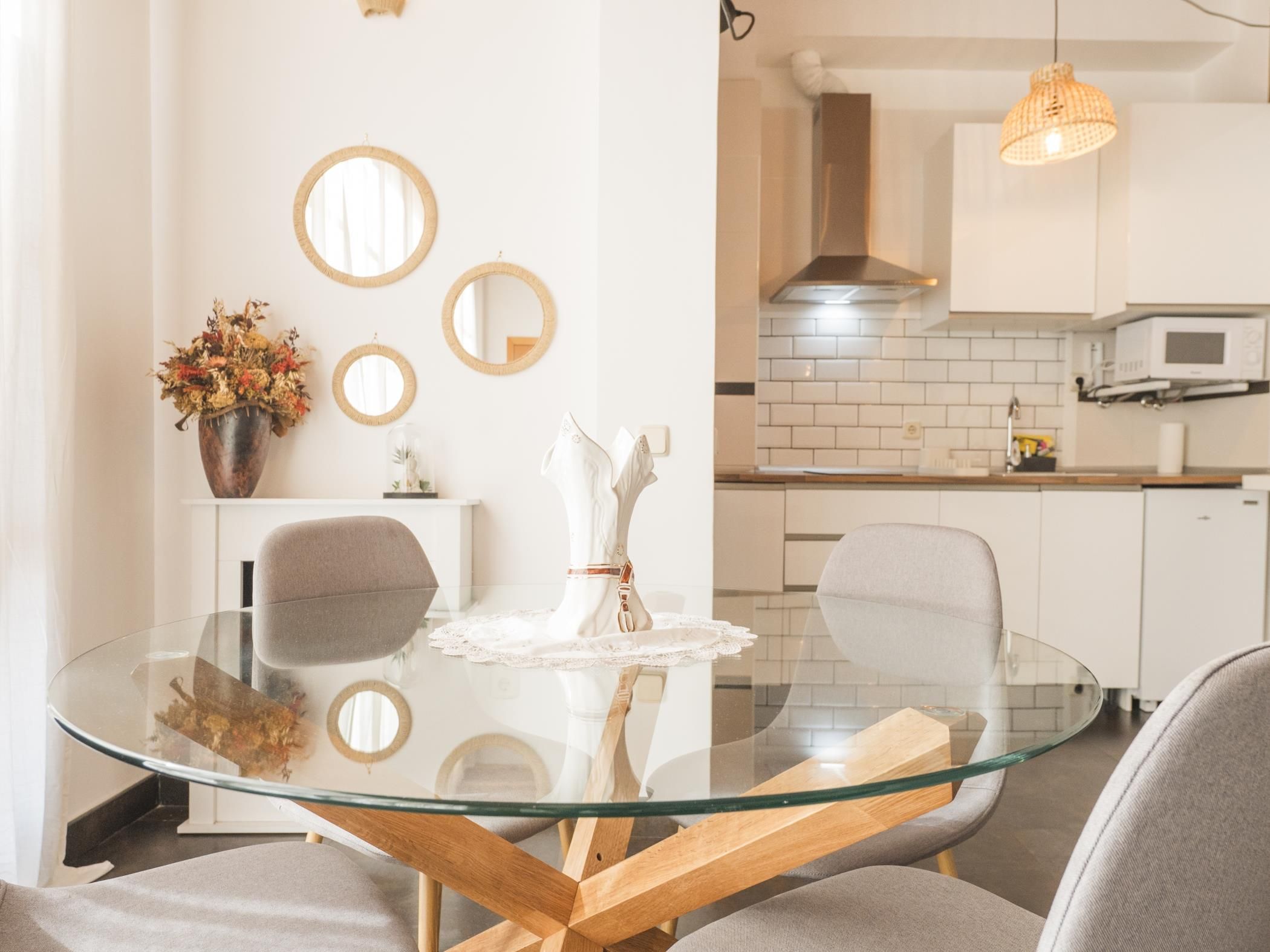A modern kitchen with white cabinets, a microwave, and a hanging light fixture.