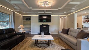 Una sala de estar con chimenea, televisor y sofá.