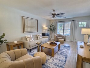 A living room with a sofa, coffee table, and a ceiling fan. - Nautilus Landing Getaway (Clarksville)