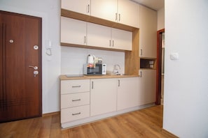 A modern kitchen with wooden cabinets, a built-in microwave, and a coffee maker. - Zabljak Hills City Center-only 400m walking distance from the center (Žabljak)