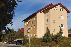 A multi-story residential building with balconies, air conditioning units, and a red roof. - Zabljak Hills City Center-only 400m walking distance from the center (Žabljak)