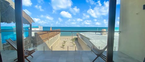 Un balcón con vista a la playa y al océano.