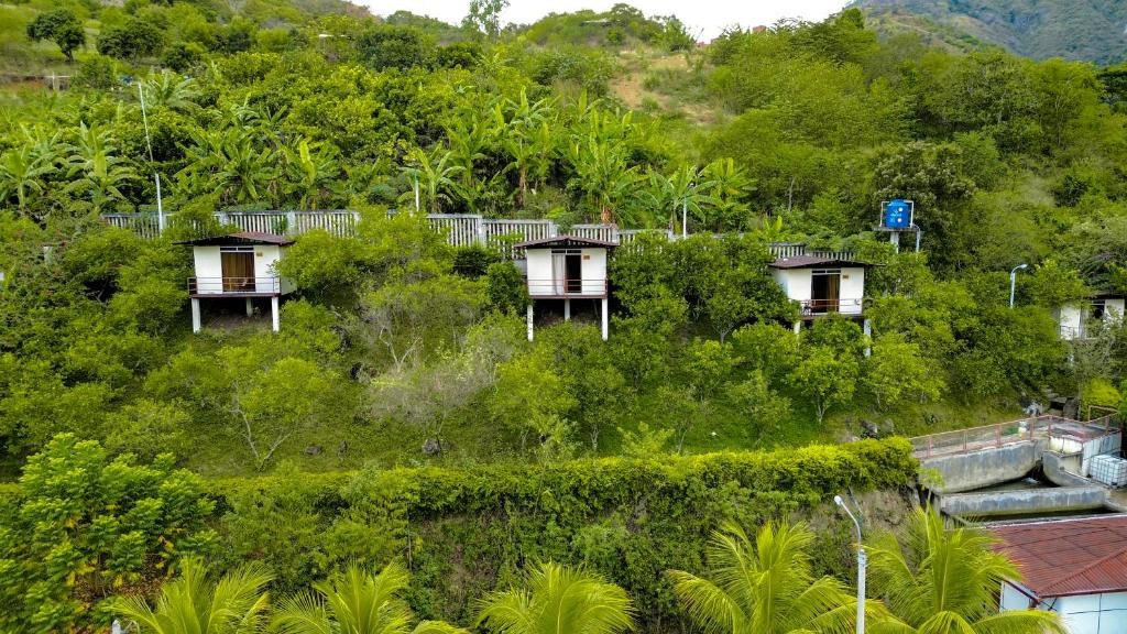 Propriedade numa encosta com vários edifícios pequenos rodeados por vegetação densa.