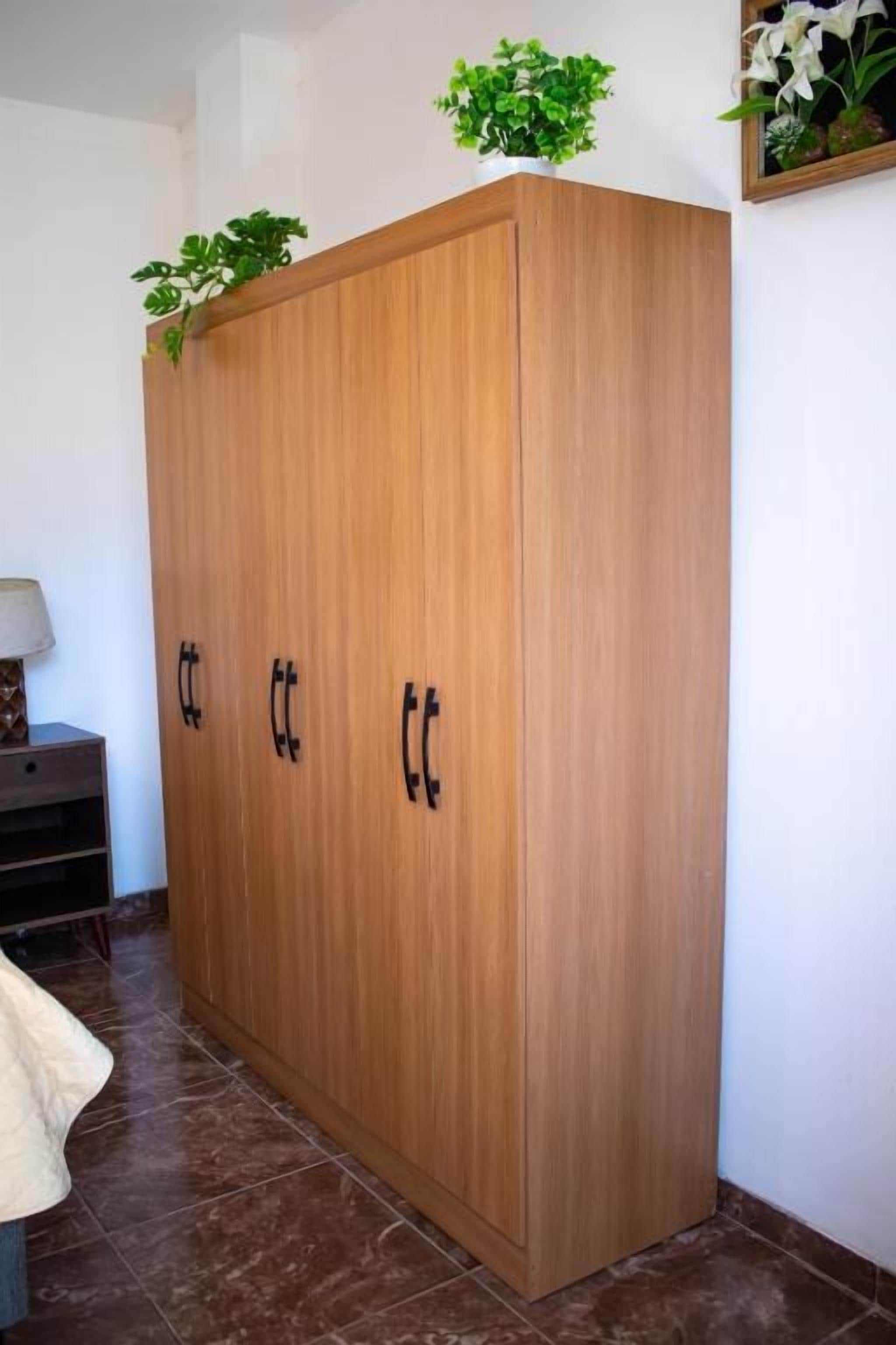 Un armario de madera con dos puertas y una repisa superior.