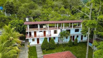 A two-story building with a flat roof, multiple windows, and a balcony on the upper floor.