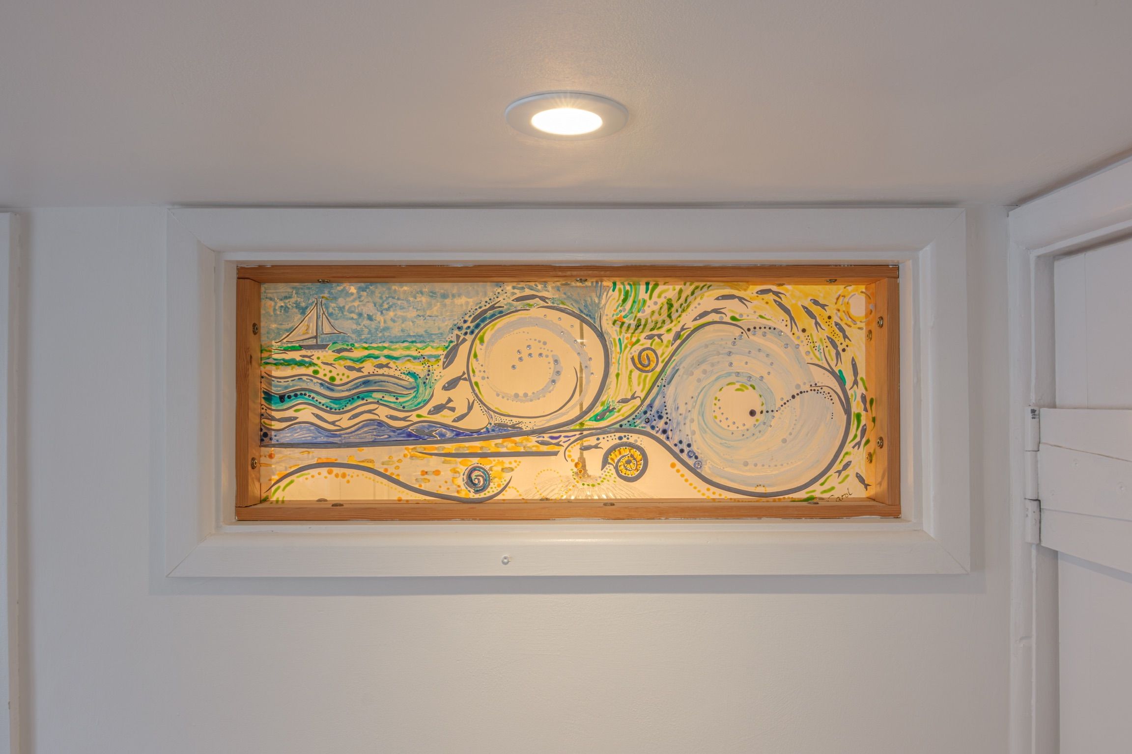 A painting in a recessed wall niche with a ceiling light above.